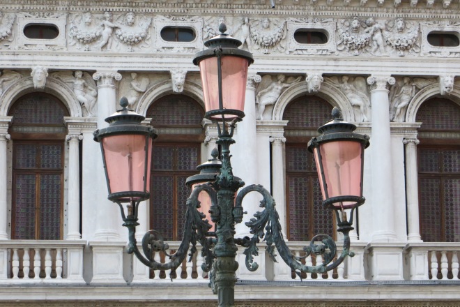 the pink glass of Venetian streetlamps